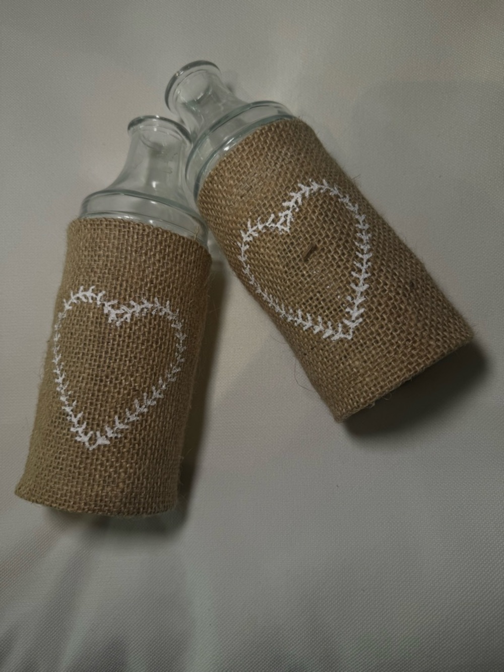 NWT - HOBBY LOBBY Burlap-Wrapped Glass Bottles w. White Heart Stitching Set of 2